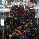 Crowds of people wearing costumes fill a Tokyo street.